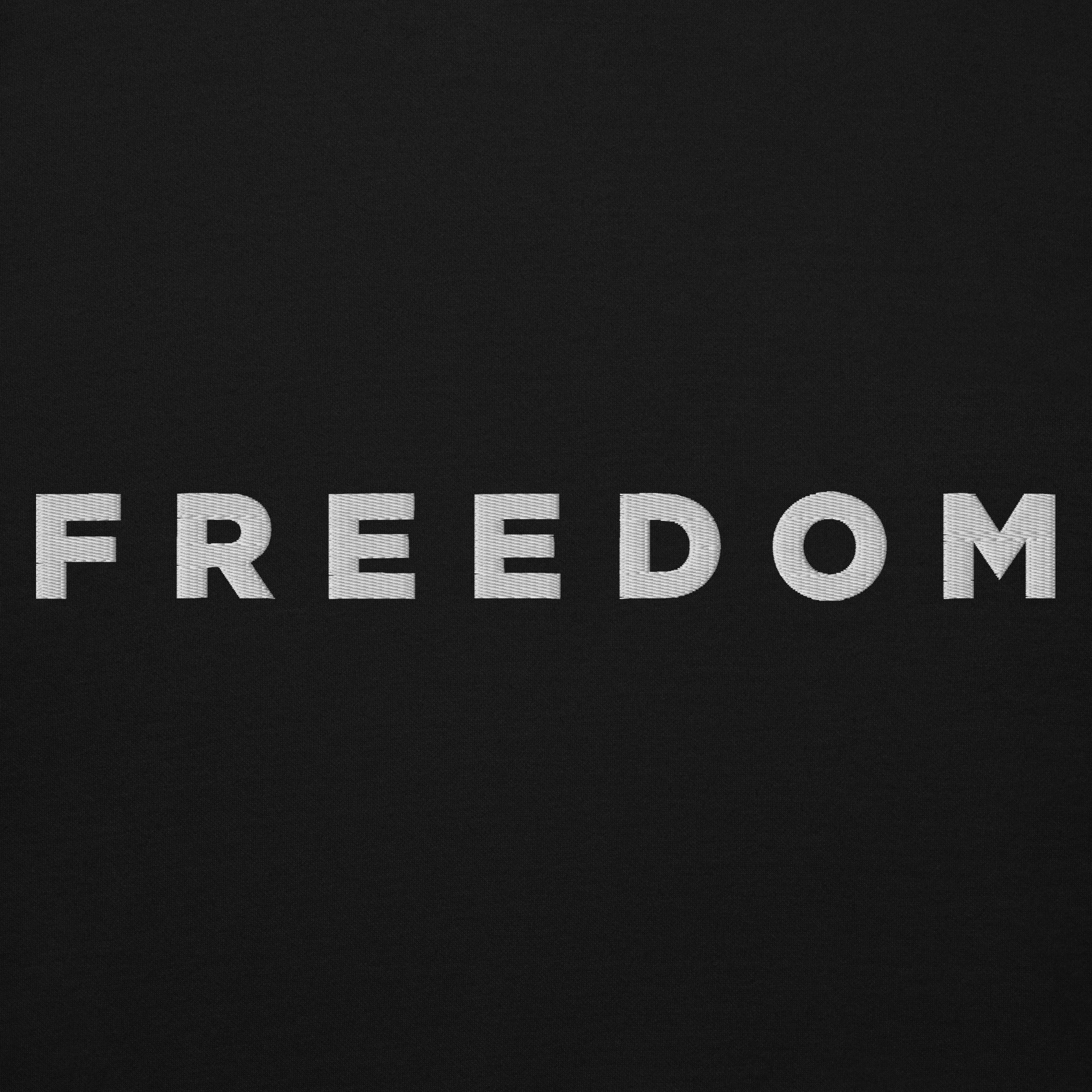 Man wearing a black hoodie with 'FREEDOM' text on a light gray background