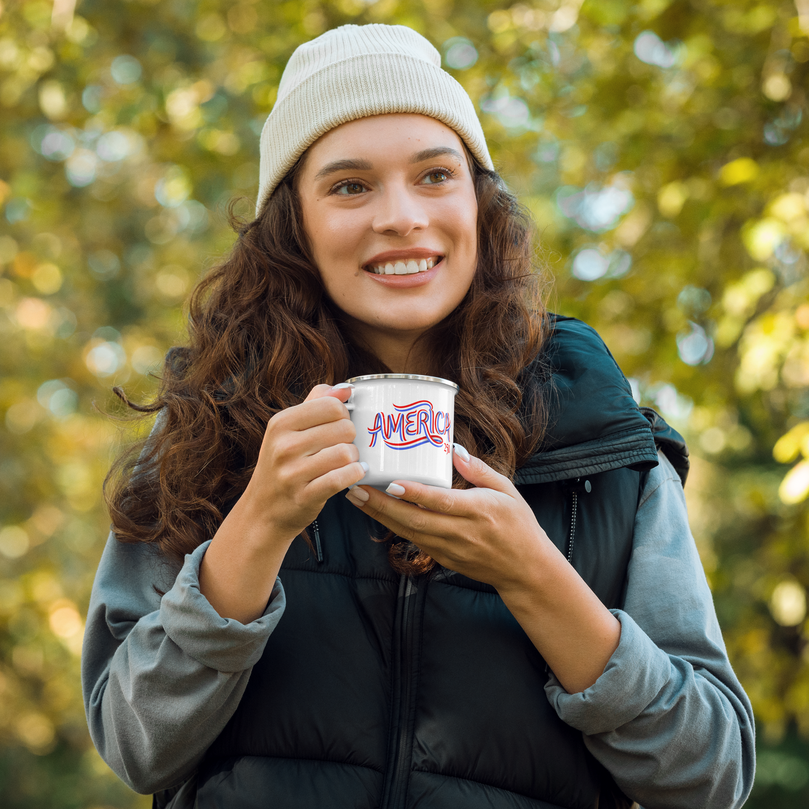 Woman holding a coffee cup outdoors with trees in the background