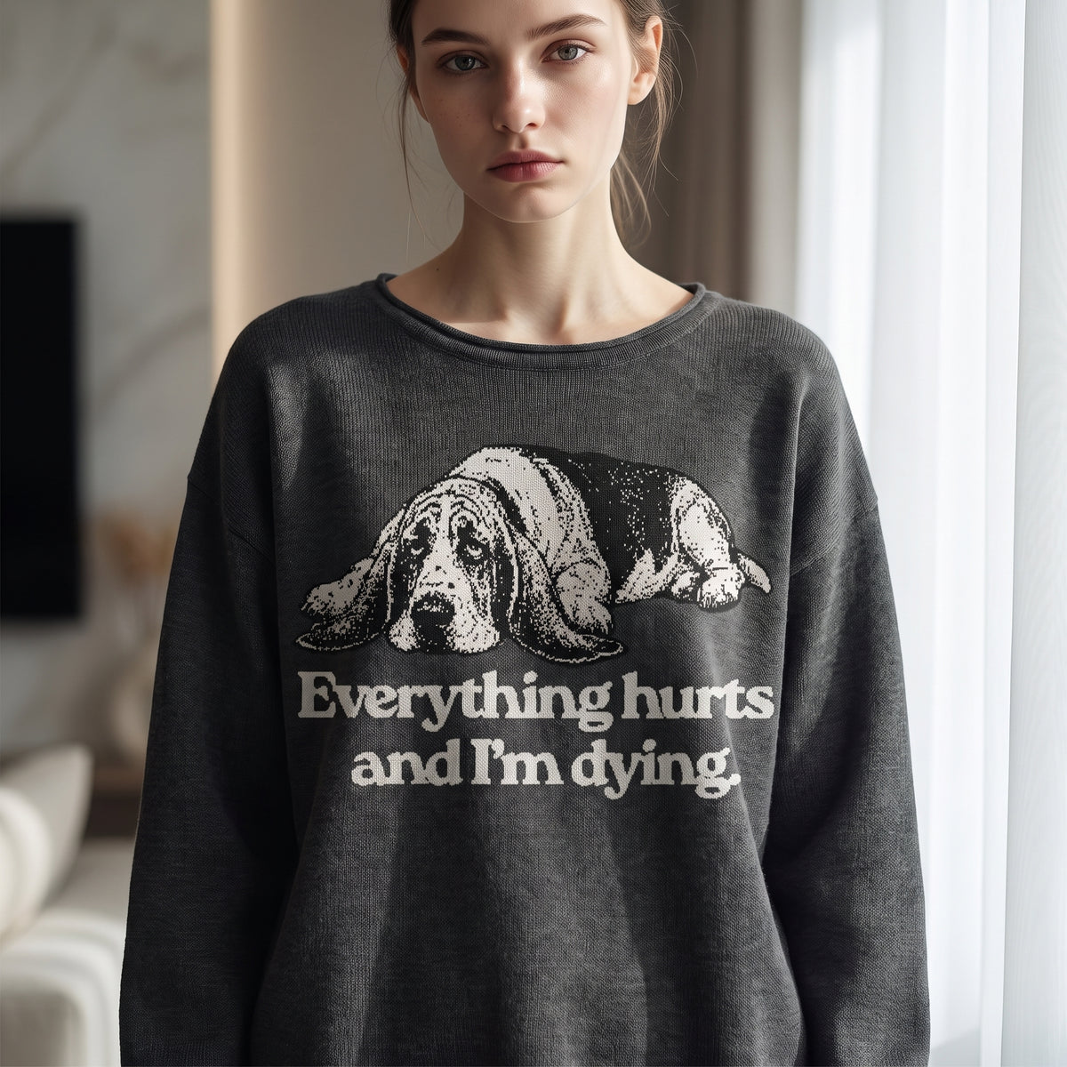 Woman wearing Everything Hurts and I'm Dying basset hound knit sweater in charcoal gray, front view