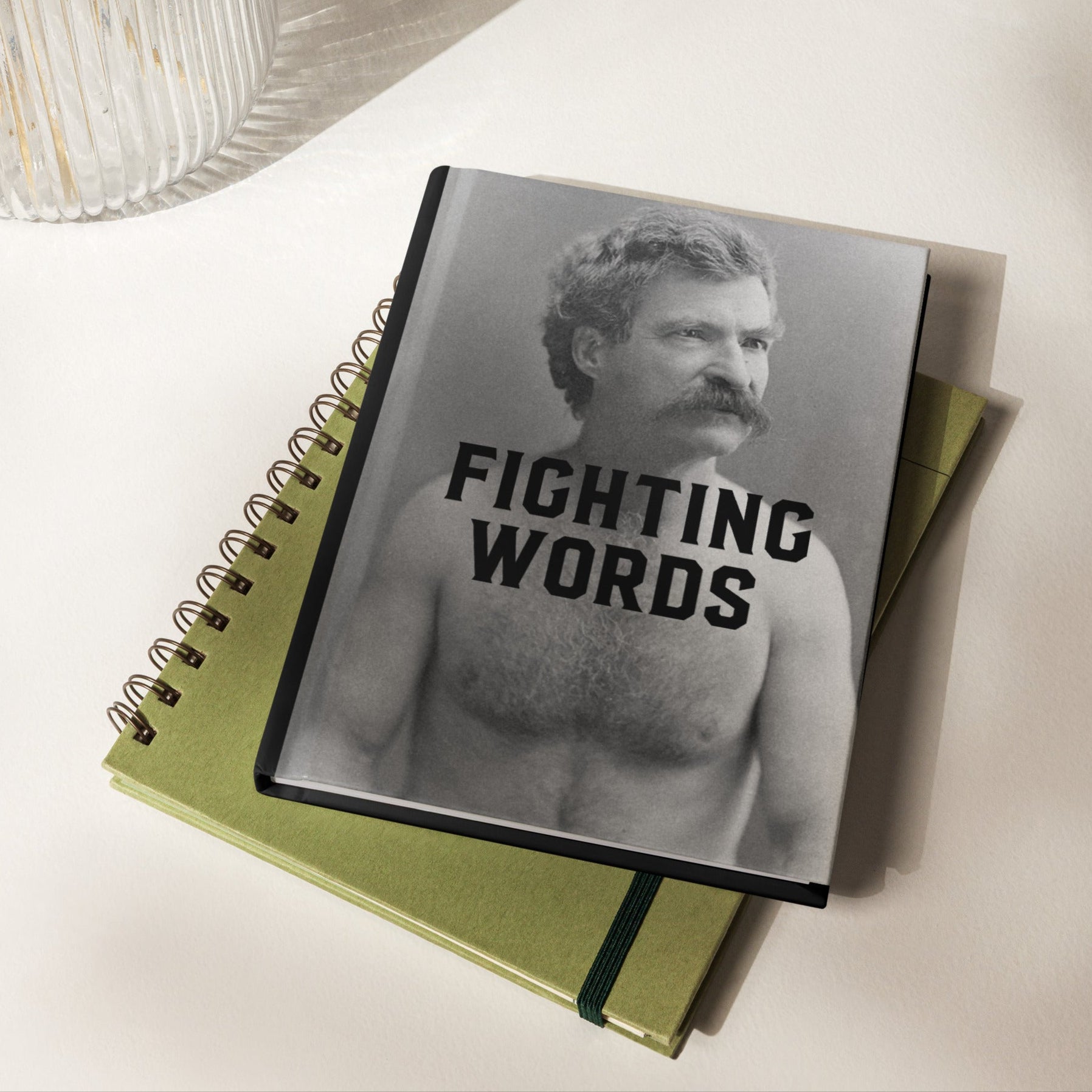Notebook with a cover featuring a black and white image of a man with 'Fighting Words' text on a light background.