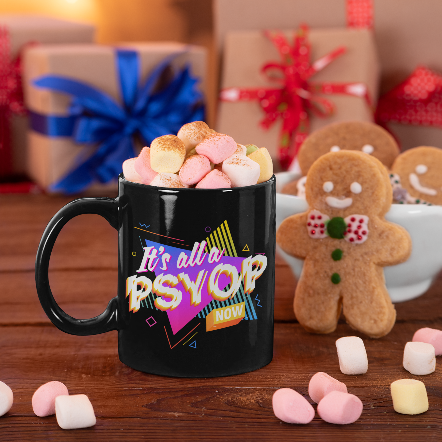 Black mug with 'It's all w PSYOP' text, surrounded by marshmallows and gingerbread men on a festive background.