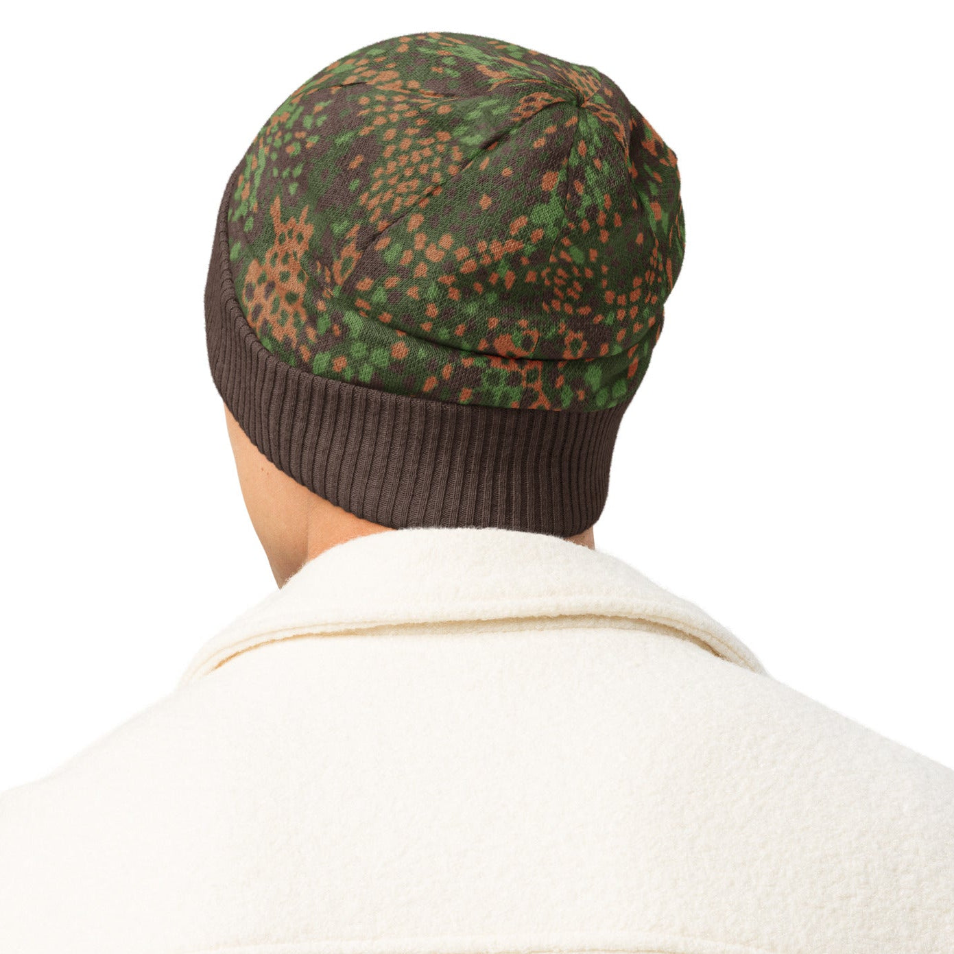 Person wearing an Erbsenmuster Pea Pattern Knitted Camouflage-patterned beanieand beige jacket on a white background