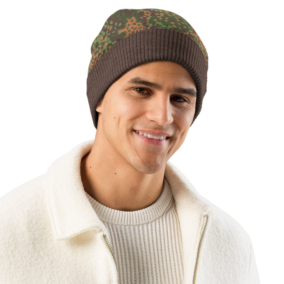 Man wearing a Erbsenmuster Pea Pattern Knitted Camouflage-patterned beanie from Liberty Maniacs and white jacket on a white background