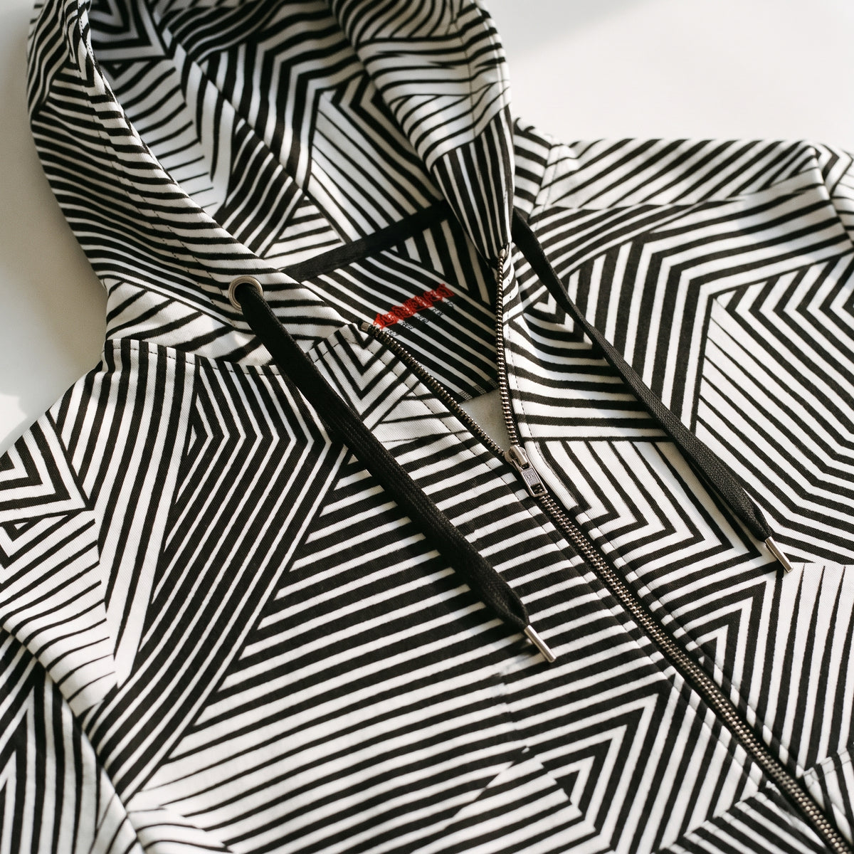 Close-up flat lay of Dazzle naval camouflage hoodie fabric and zipper
