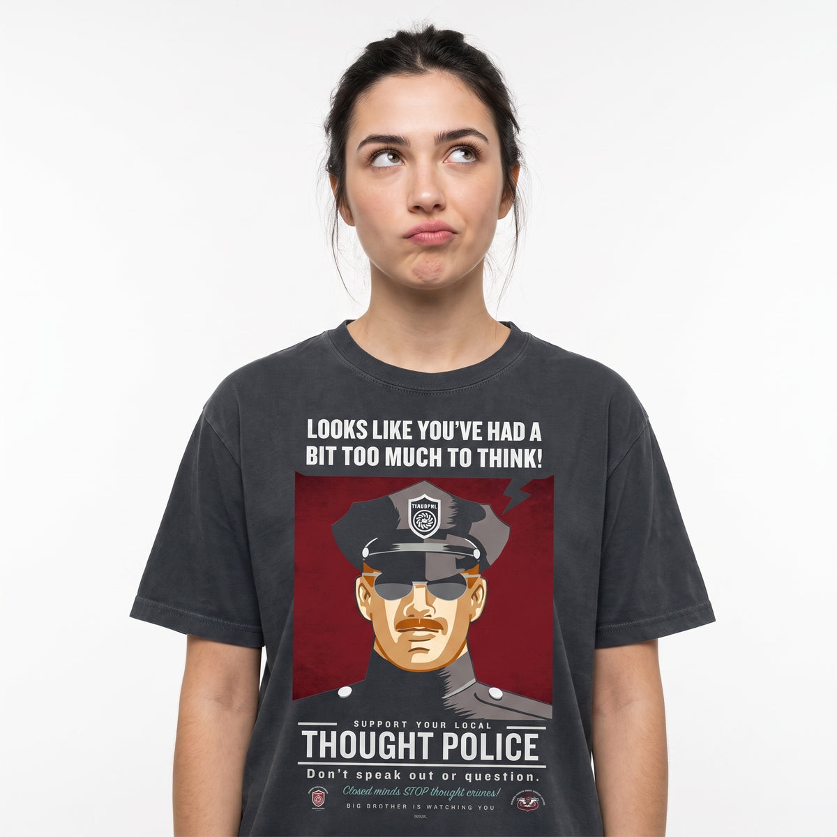 A woman wearing a dark gray graphic t-shirt with a satirical Liberty Maniacs Thought Police t-shirt that says, 'It looks like you've had too much to think."