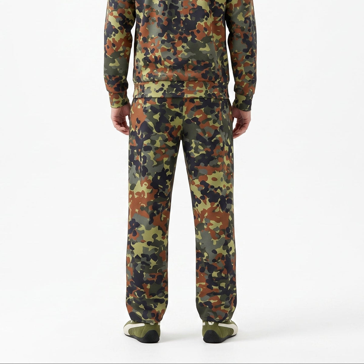 A man viewed from the back wearing a matching camouflage tracksuit with a high collar and zip-up jacket, paired with matching pants and olive green shoes, against a plain white studio background.