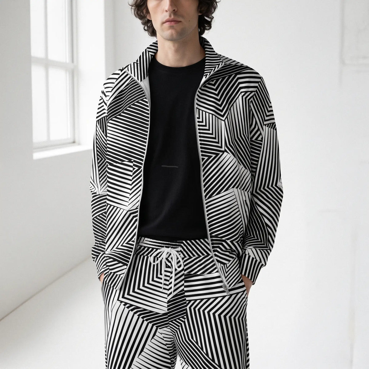 Man in a studio wearing a Dazzle Track Jacket and matching track pants by Liberty Maniacs.