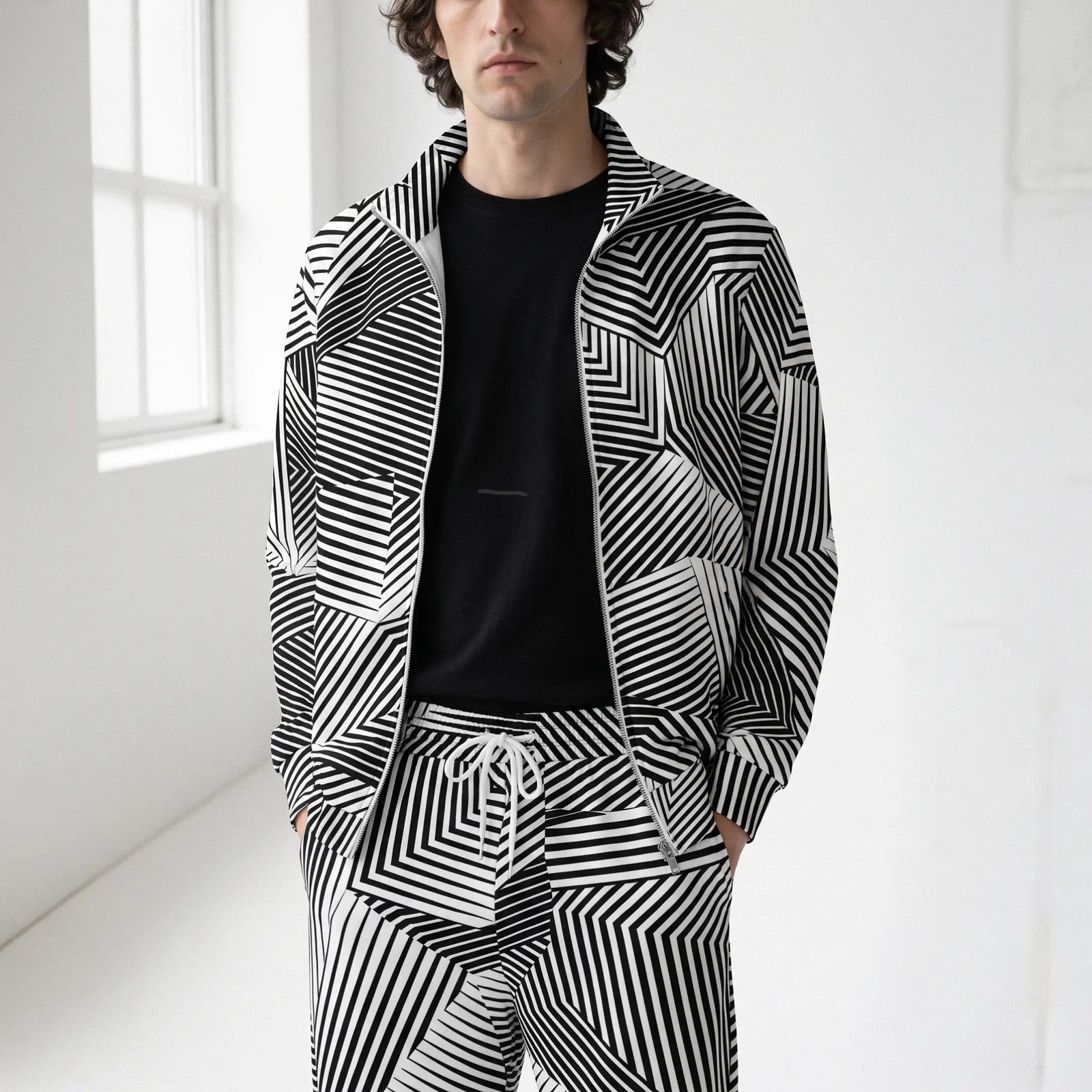 Man in a studio wearing a Dazzle Track Jacket and matching track pants by Liberty Maniacs.