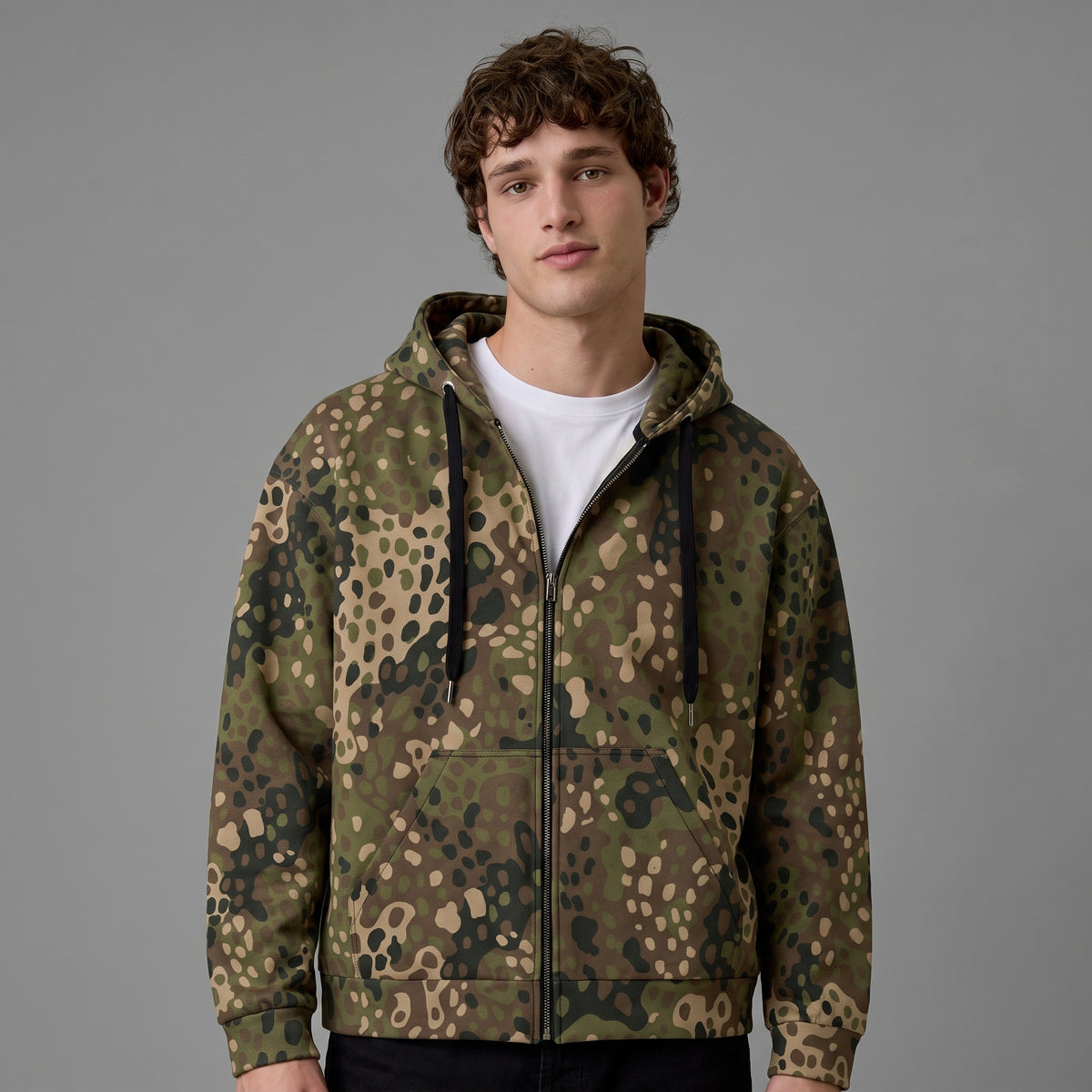 Man wearing the Erbsenmuster Pea Dot Field Green zip hoodie, front view