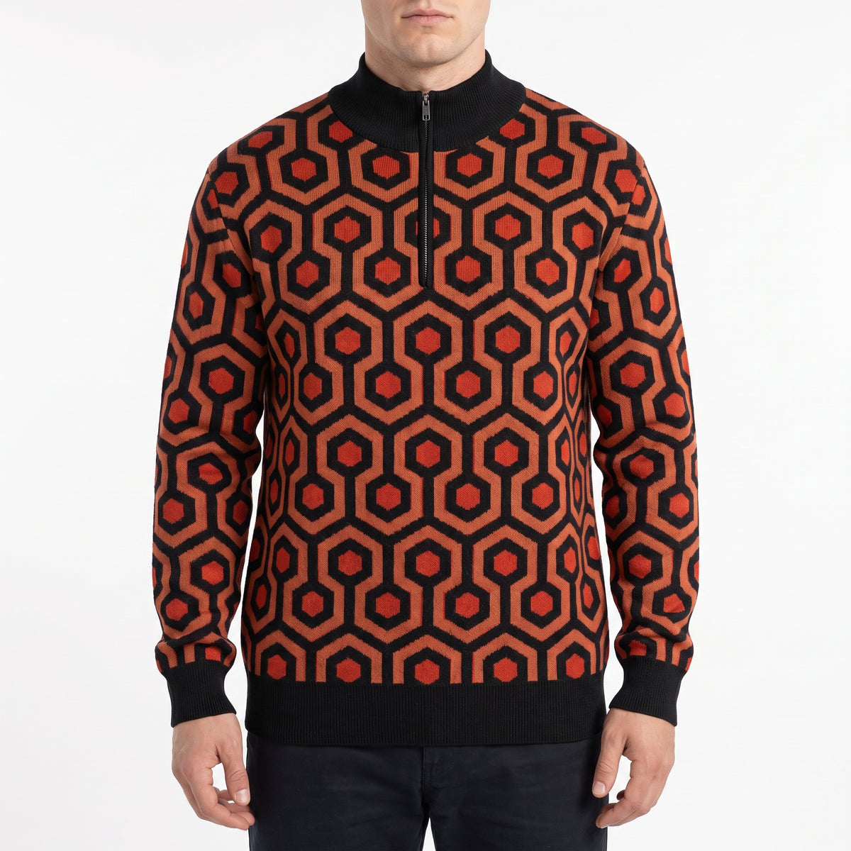 Man modeling the Overlook Knit Quarter Zip sweater with the orange, red, and black carpet pattern from The Shining.