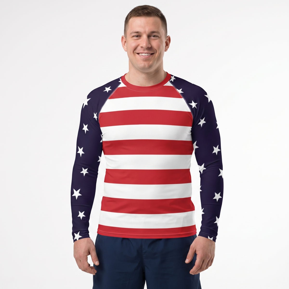 A man wearing a long-sleeve athletic shirt with an American flag pattern, featuring red and white horizontal stripes on the torso and navy blue sleeves with white stars, against a plain white background.