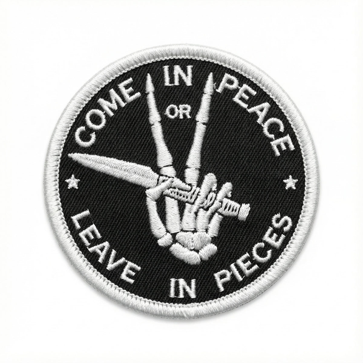Patch with a hand holding scissors and text &#39;Come in peace or leave in pieces&#39; on a black background.