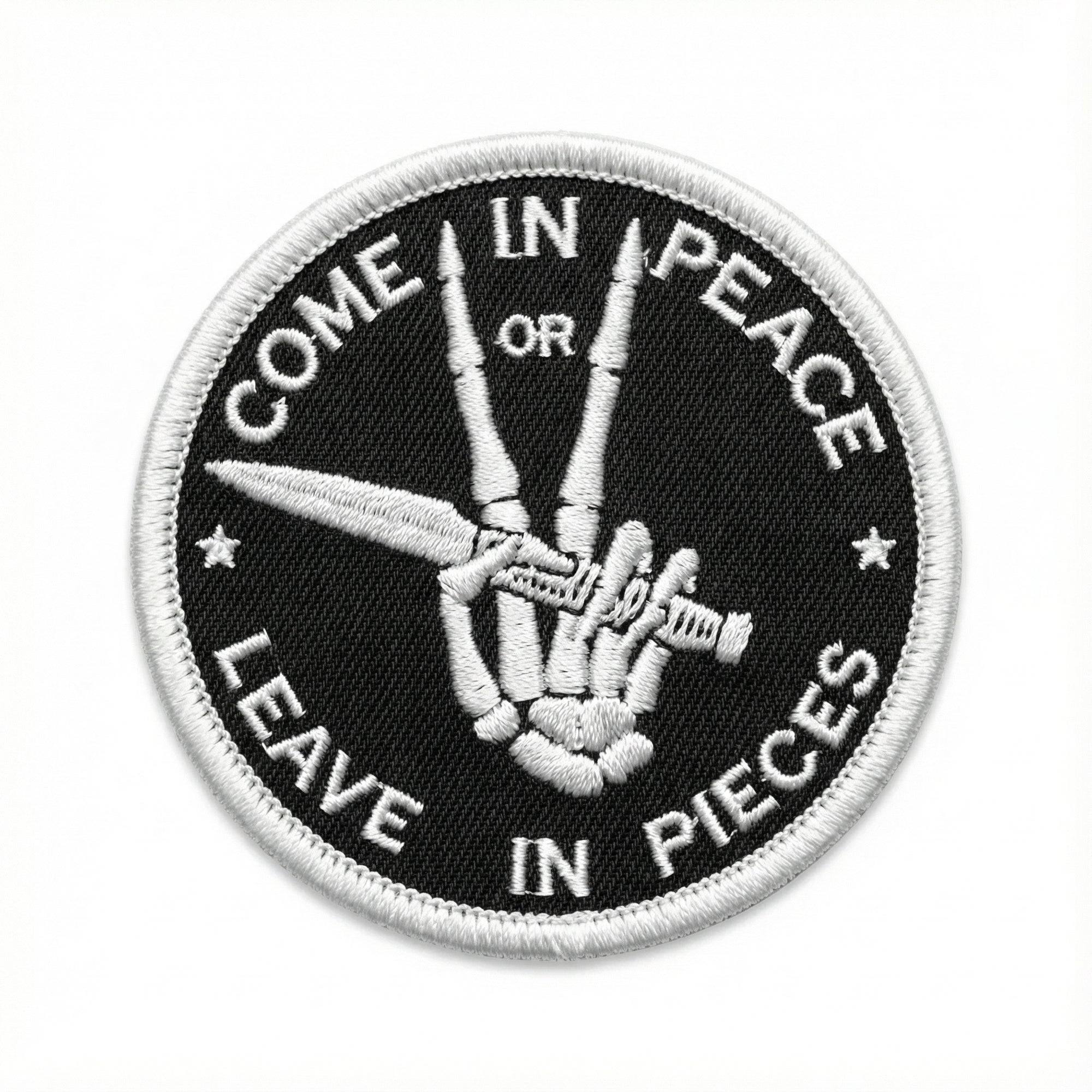 Patch with a hand holding scissors and text 'Come in peace or leave in pieces' on a black background.