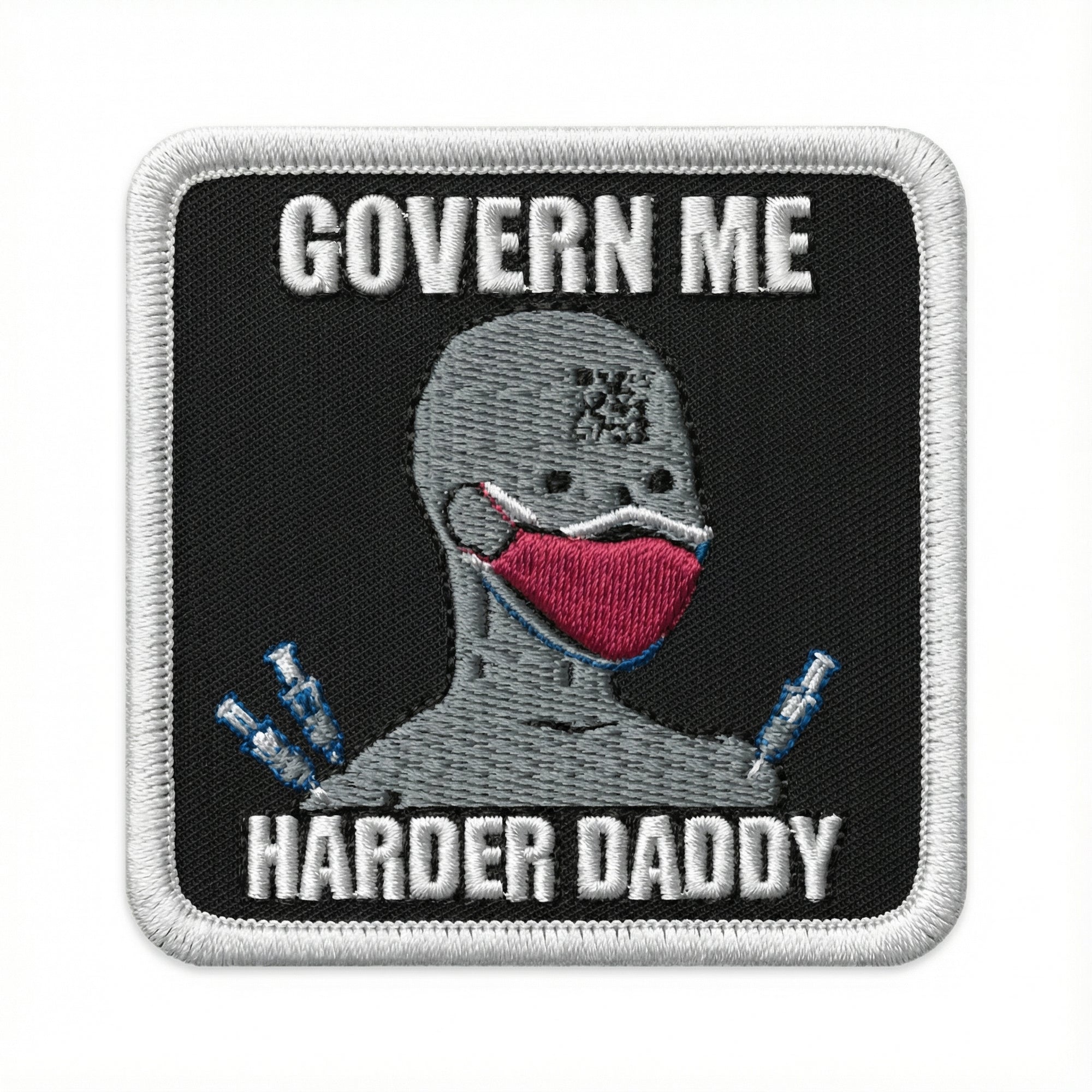 Embroidered patch with a NPC wearing a mask and text ' Govern Me Harder Daddy' on a black background.