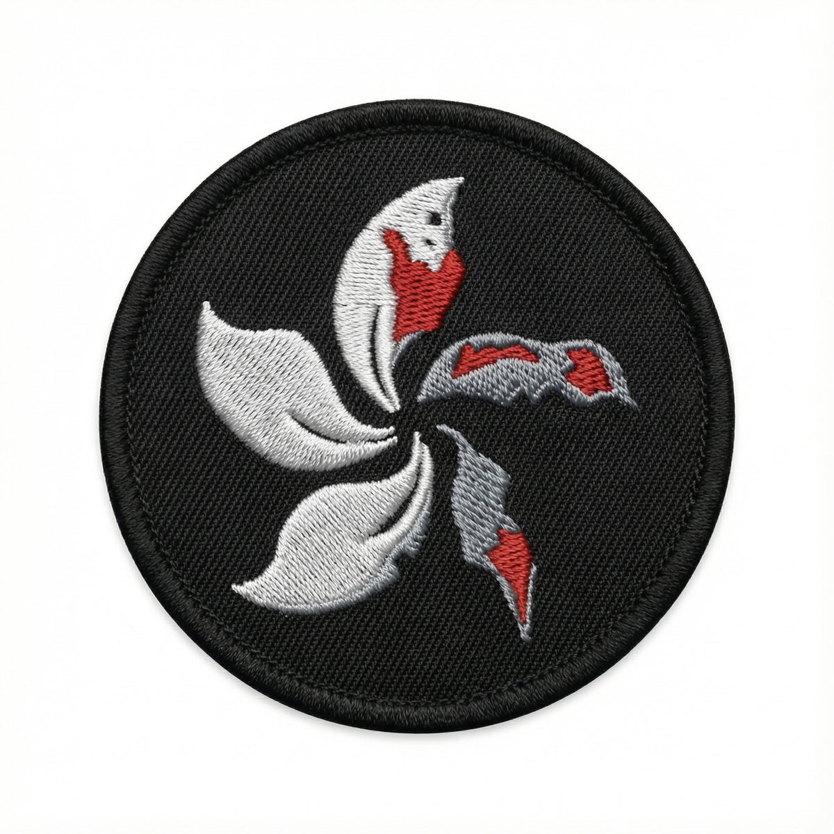 Round patch with a white and red floral design on a black background