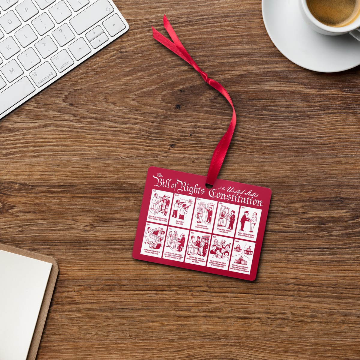 Red &#39;Bill of Rights Constitution&#39; ornament on a wooden desk with a keyboard and coffee cup.