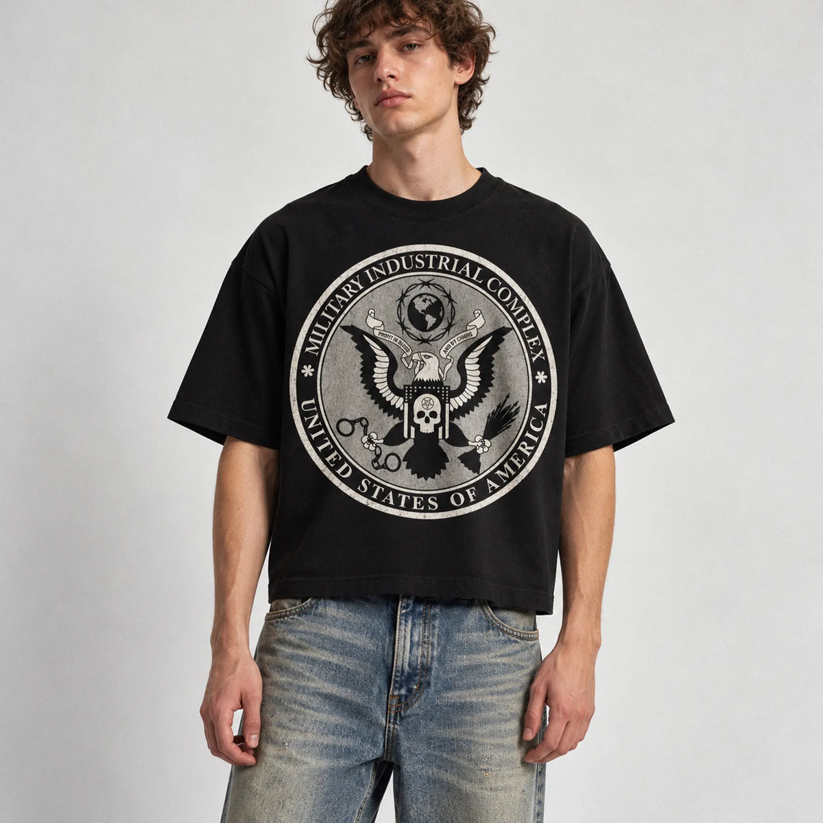 Model wearing black Military Industrial Complex boxy graphic tee, front studio view