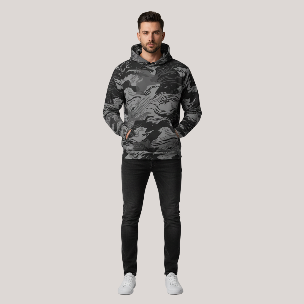 Man wearing a camouflage hoodie and black pants on a light gray background