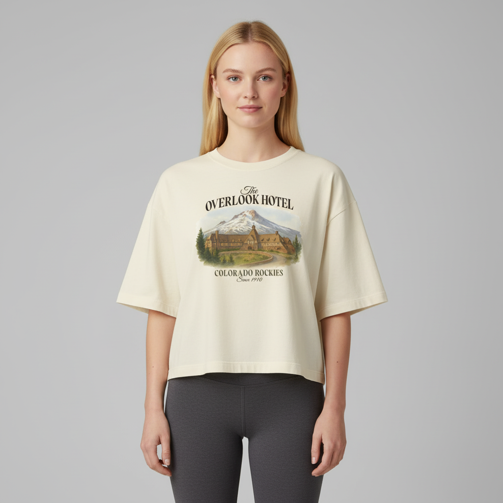 Woman wearing a beige t-shirt with 'The Overlook Hotel' graphic design on a gray background