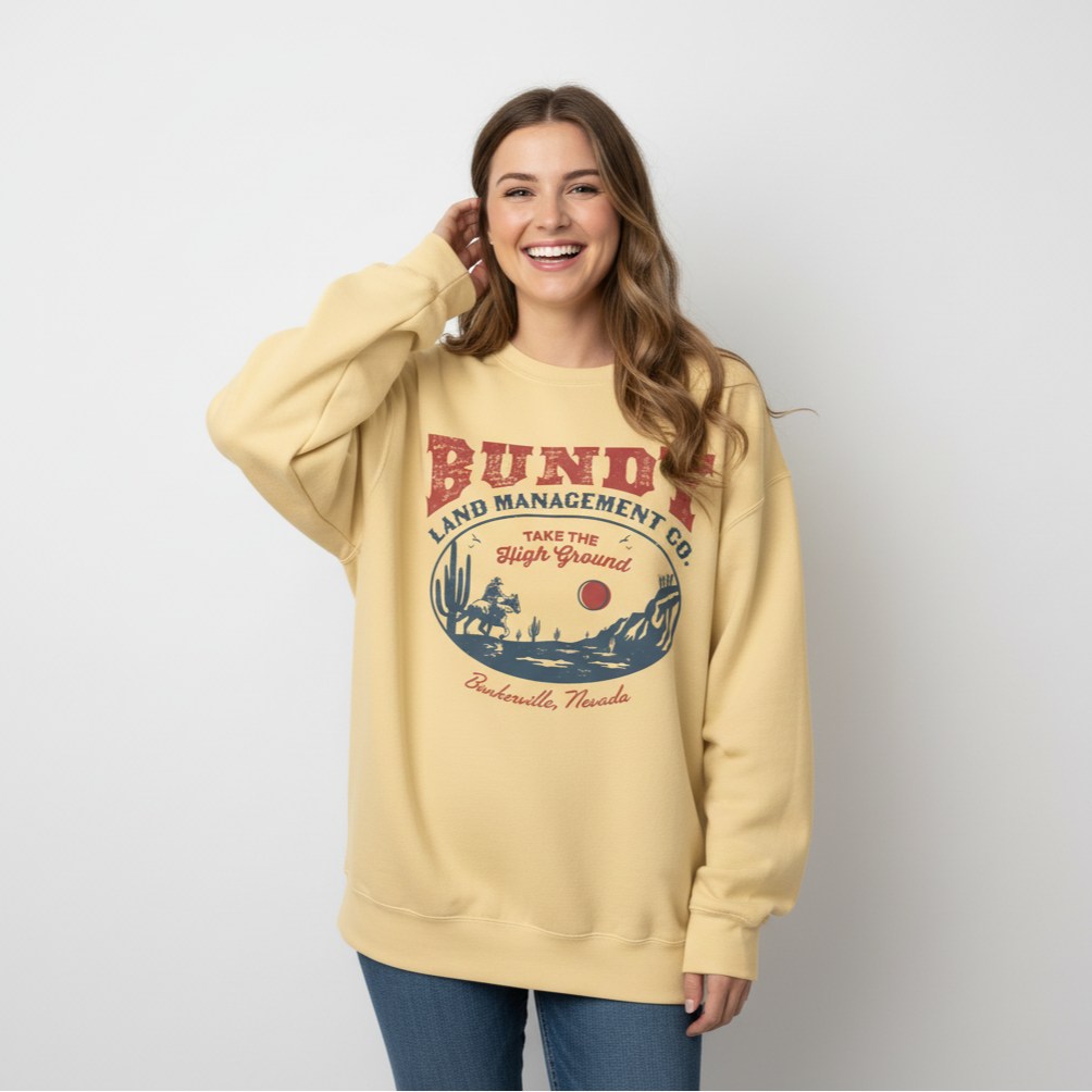 Woman wearing a beige sweatshirt with a graphic design on a plain background