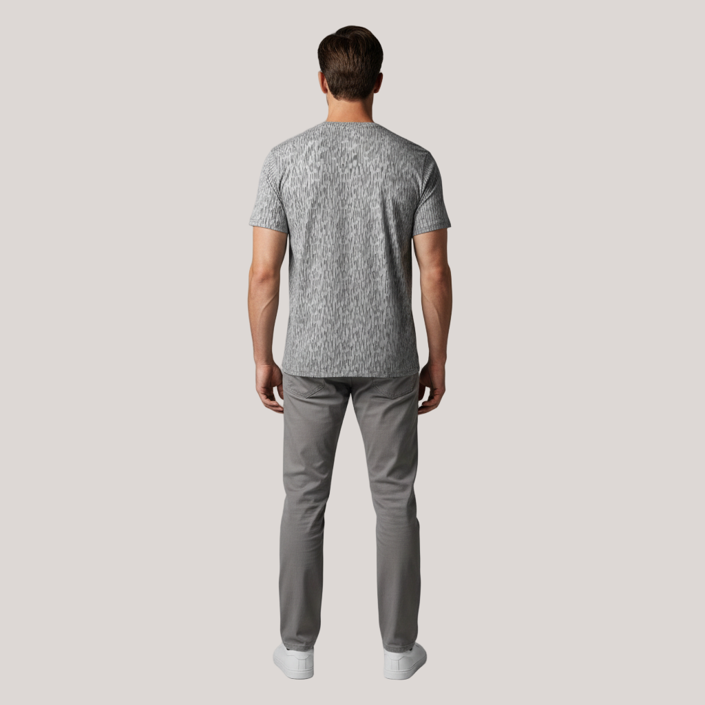 Man wearing a gray patterned Strichtarn Line Camo Men’s T-Shirt and gray pants on a gray background