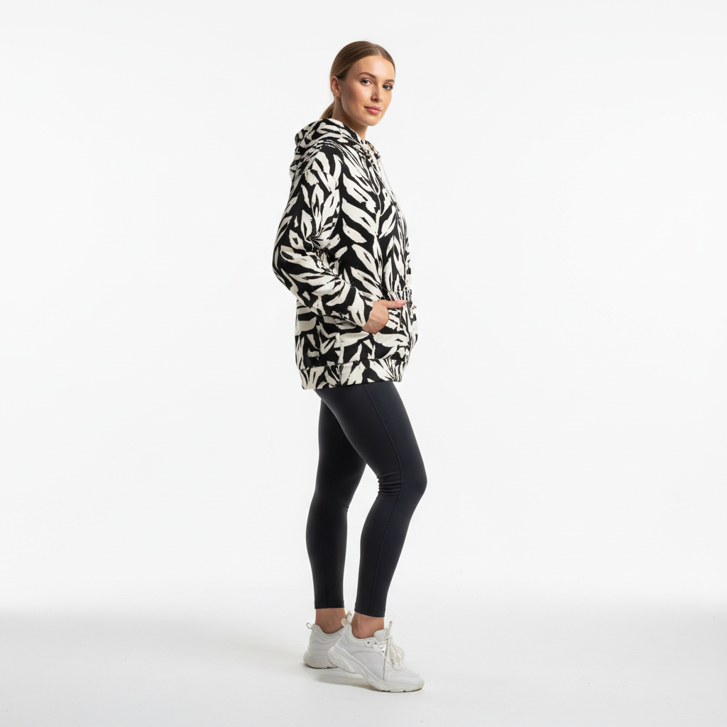 Woman wearing a patterned hoodie and black leggings on a white background