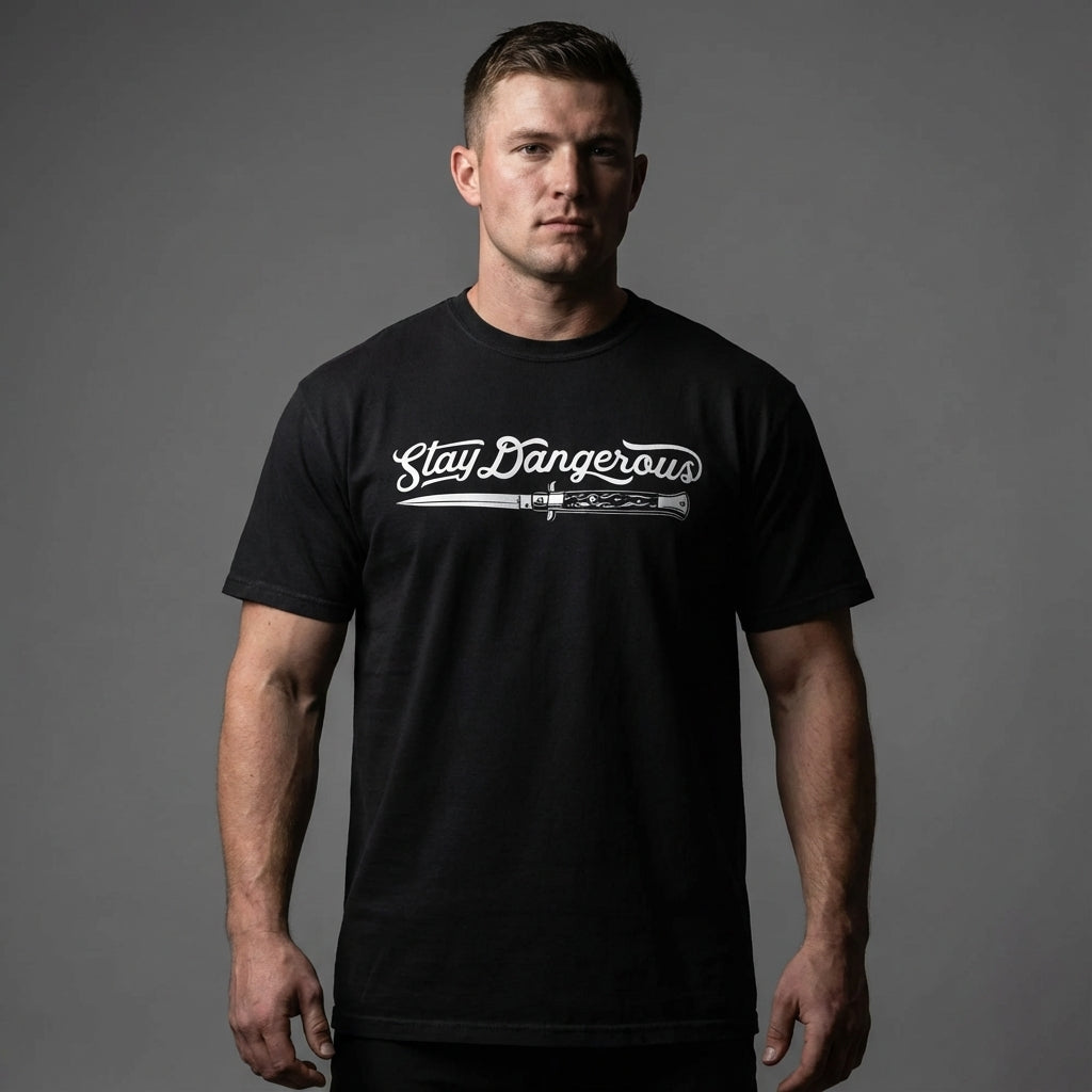 Man wearing a black t-shirt with 'Stay Dangerous' text and graphic on a gray background