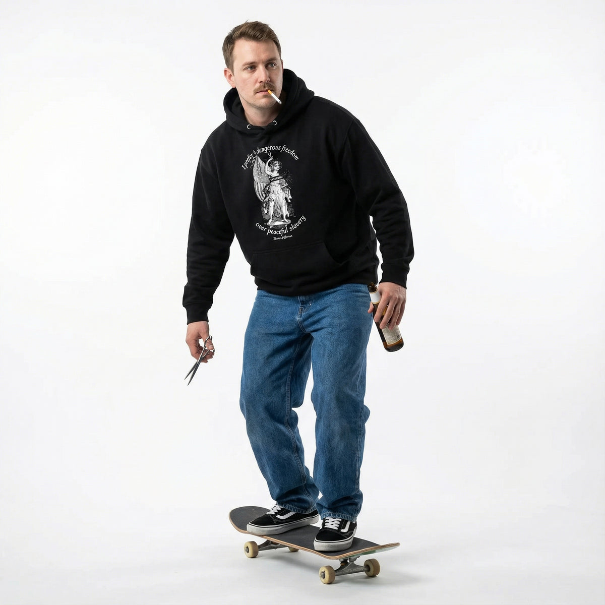 Man wearing a black hoodie and blue jeans, standing on a skateboard with a white background