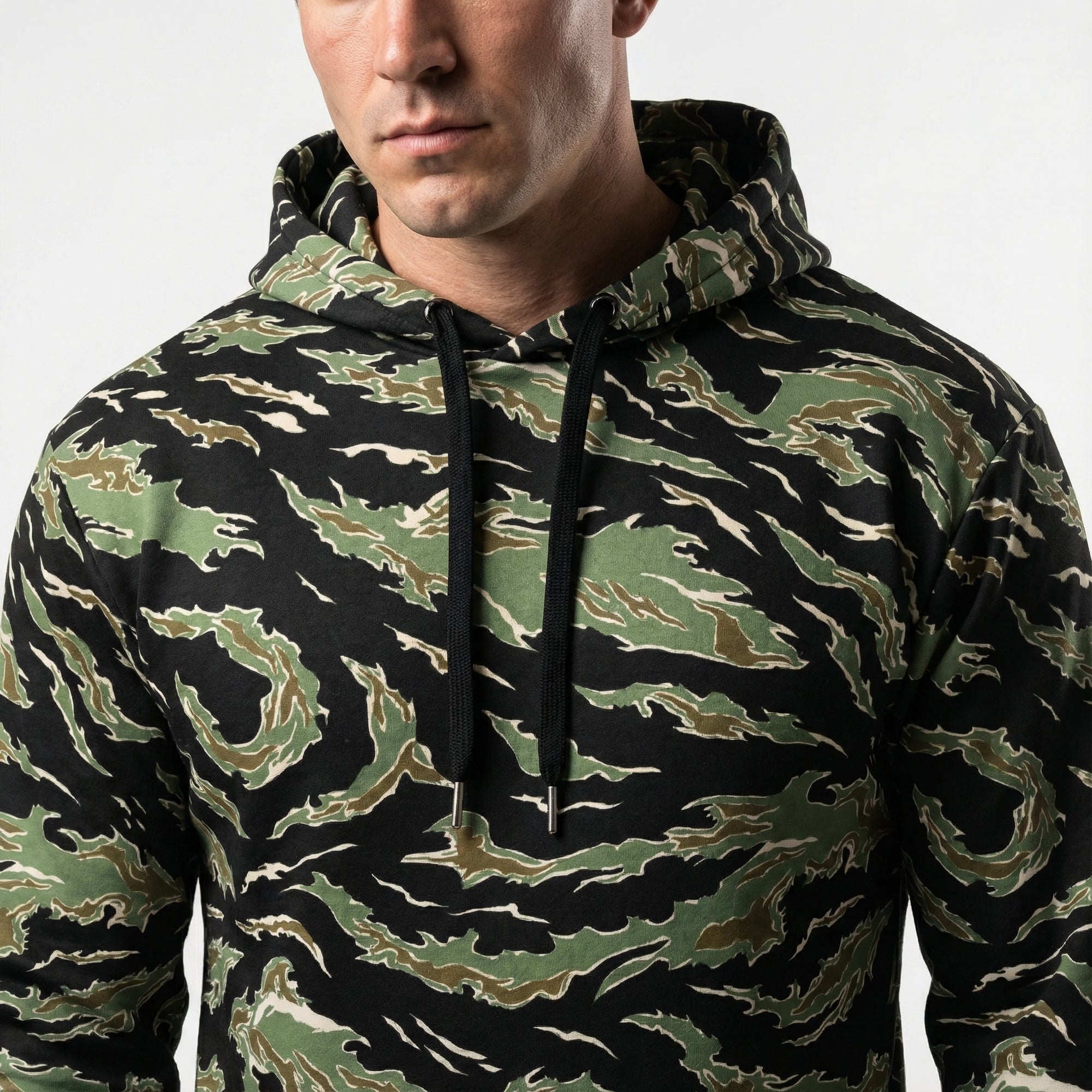 Person wearing a camouflage hoodie on a white background