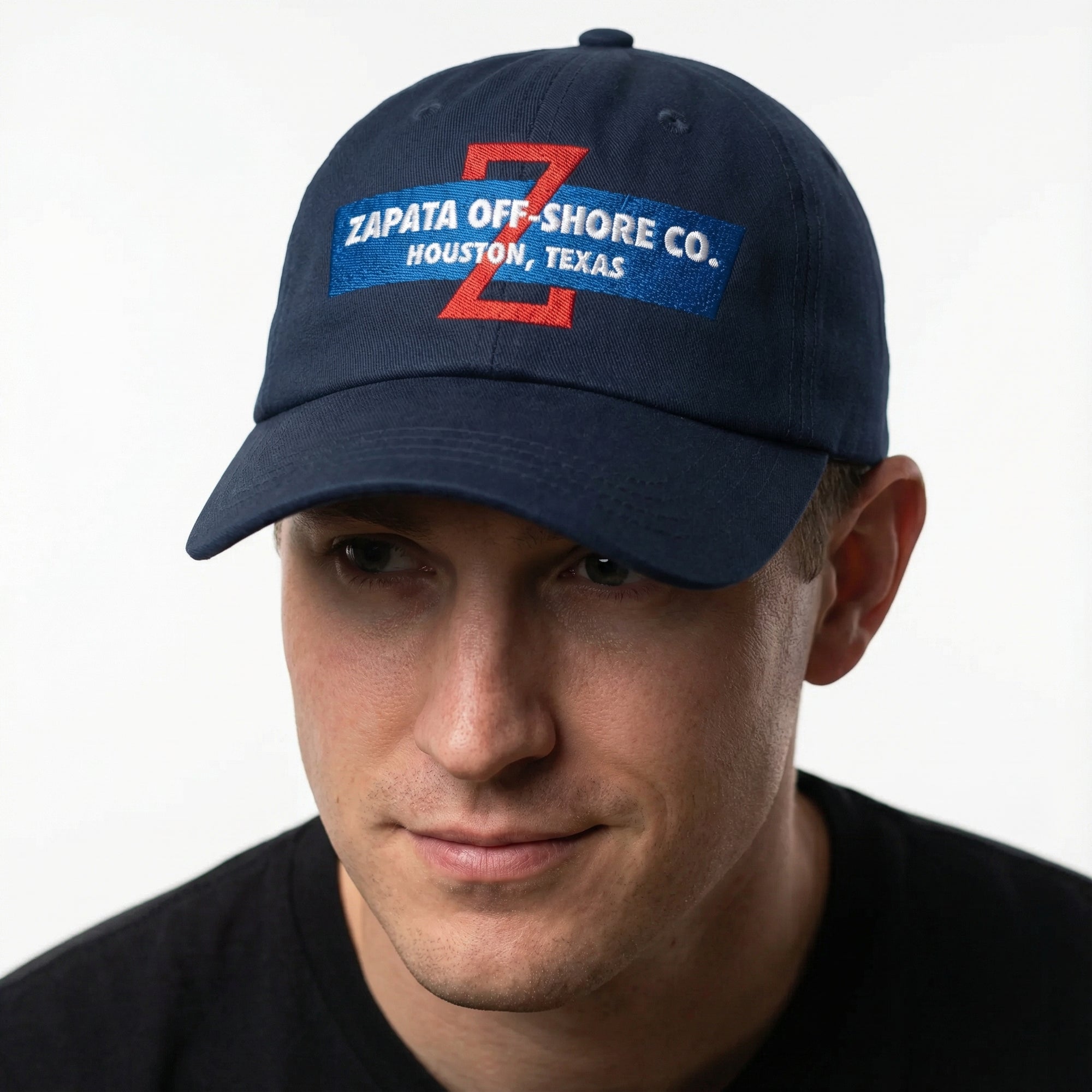Man wearing a navy blue cap with Zapata Off-Shore Co. branding on a white background