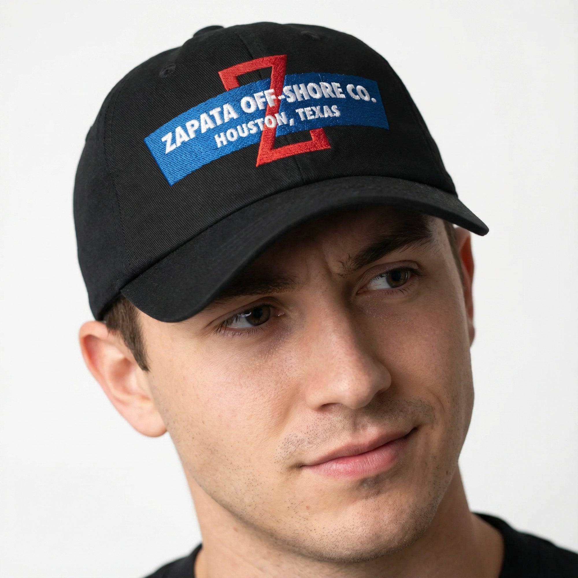 A black baseball cap with 'ZAPATA OFF-SHORE CO. HOUSTON, TEXAS' embroidered in red and blue on the front.