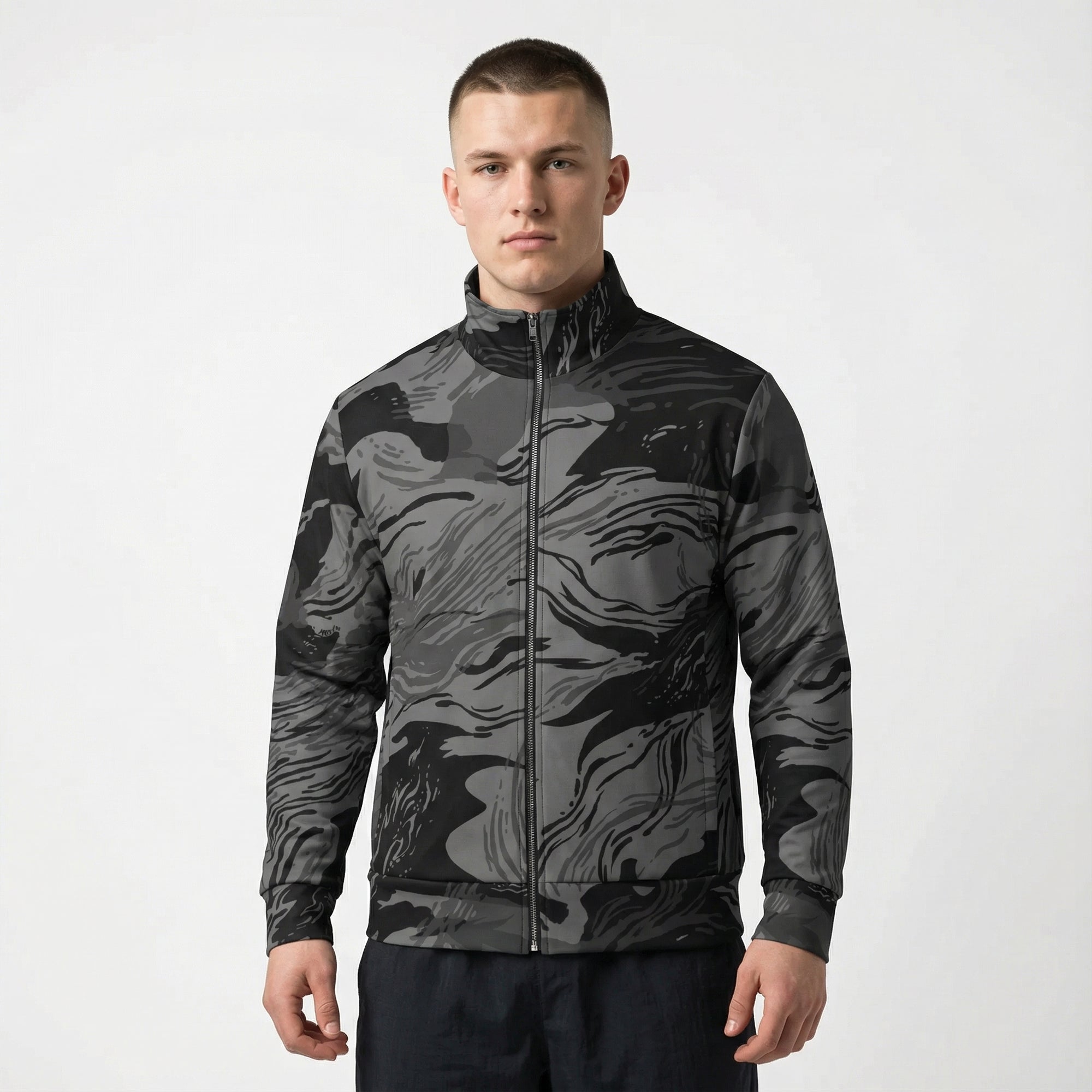 Man wearing a black and gray camouflage jacket on a white background