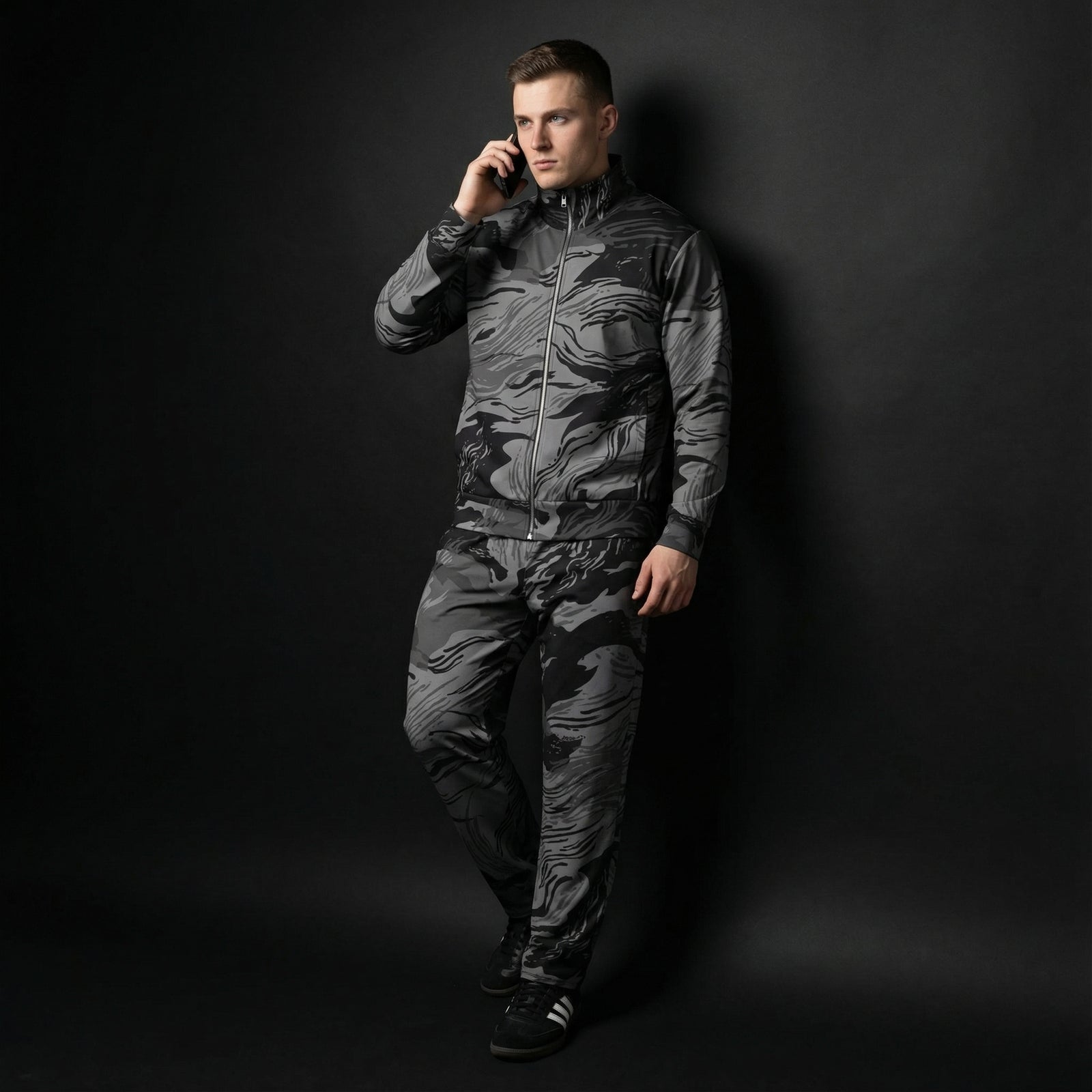 Man wearing a camouflage jumpsuit against a black background