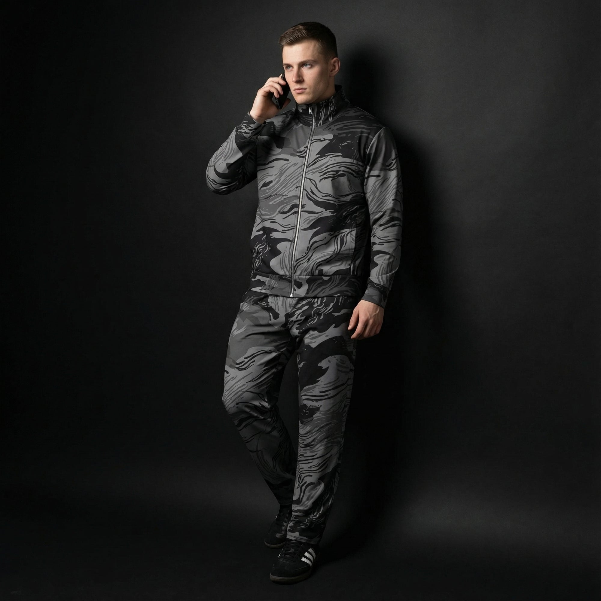 Man wearing a camouflage jumpsuit against a black background