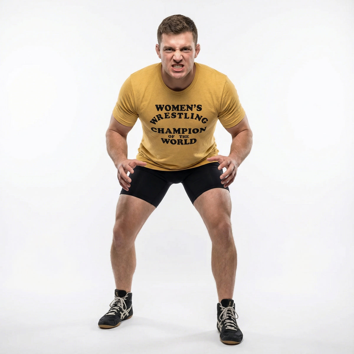 Man wearing a yellow t-shirt with ext 'WOMEN'S WRESTLING CHAMPION OF THE WORLD' and black shorts on a white background