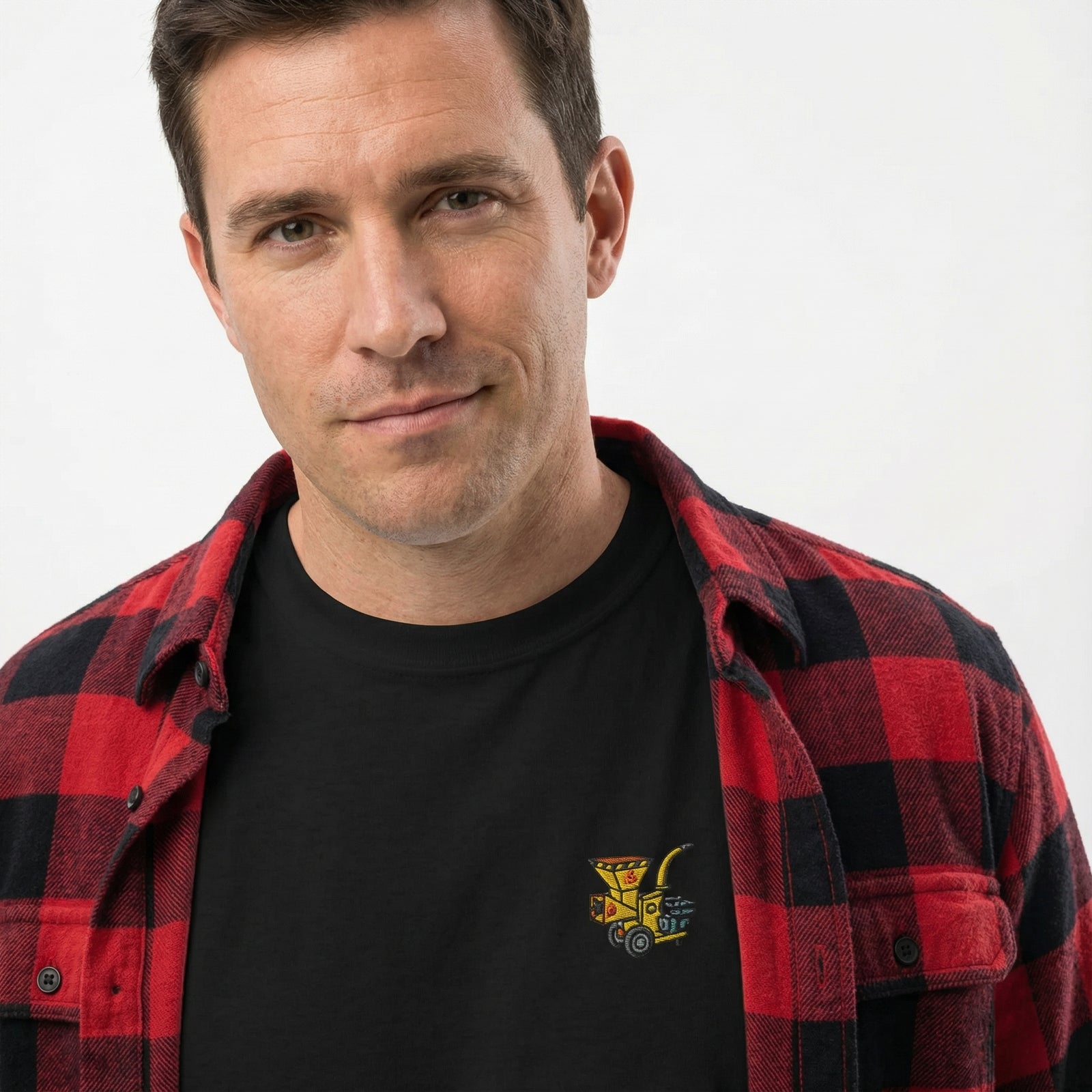 Man wearing a black long-sleeve shirt with a woodchipper embroidered on the front chest on a white background