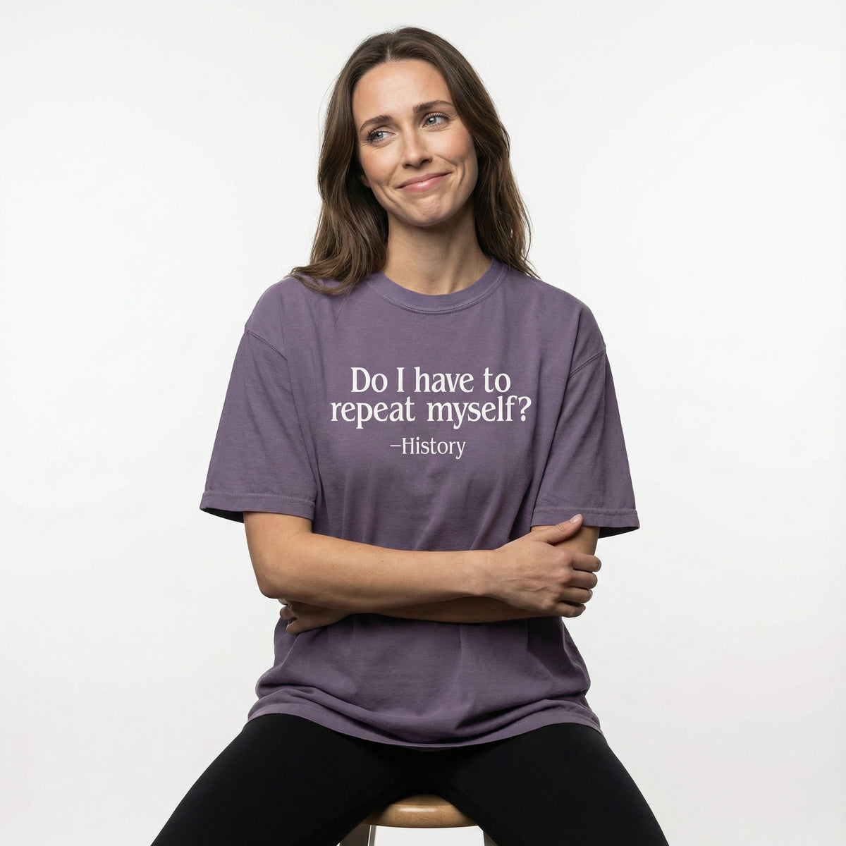 Woman wearing a purple t-shirt with a humorous quote on a white background