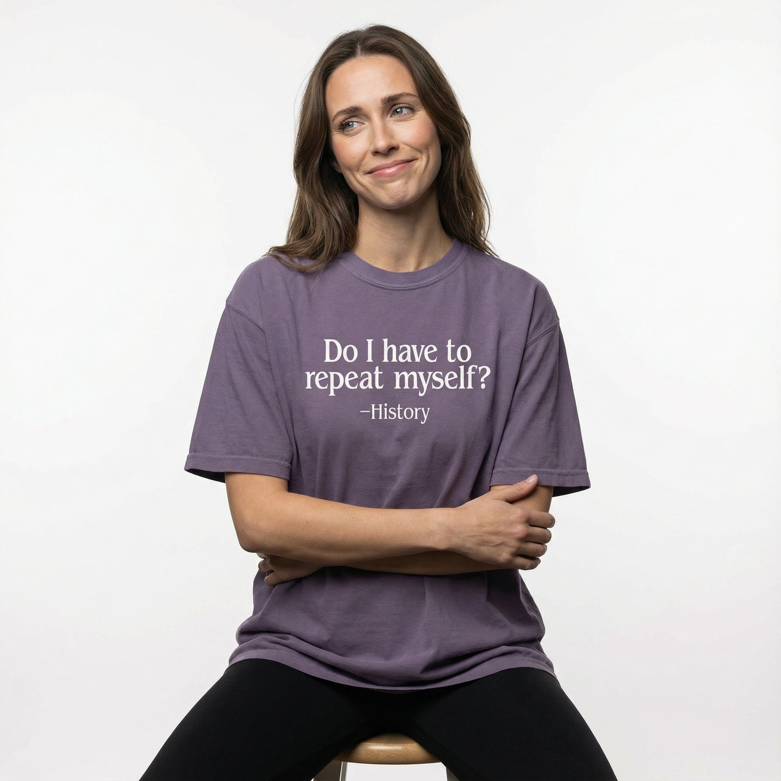 Woman wearing a purple t-shirt with a humorous quote on a white background