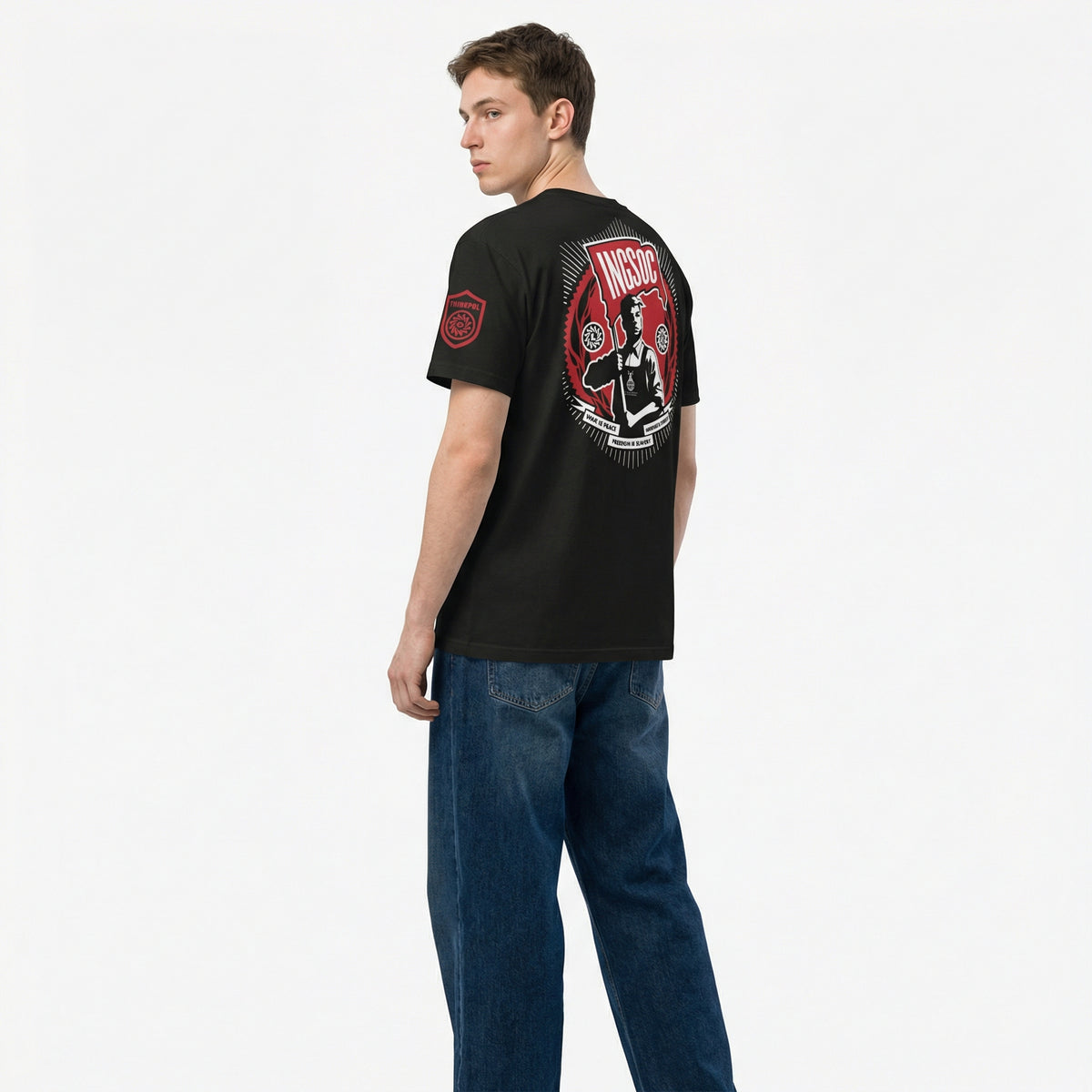 Person wearing a black t-shirt with a graphic design on the back, standing against a white background