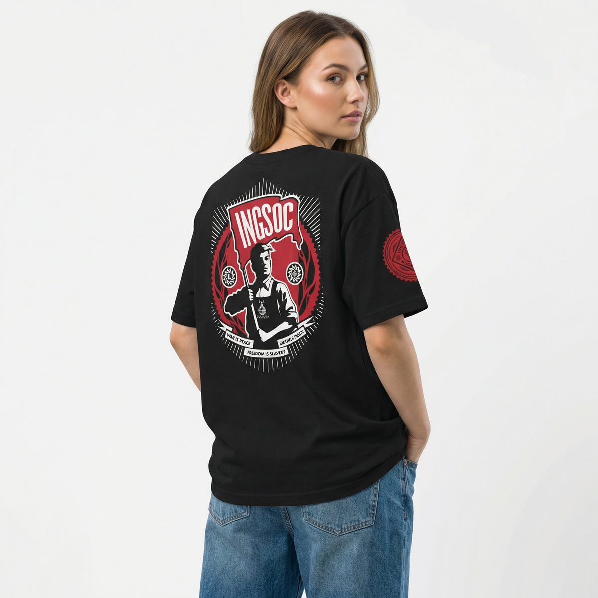 Person wearing a black t-shirt with a graphic design on the back, standing against a white background