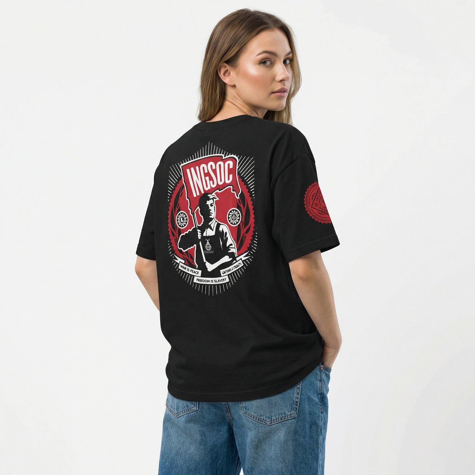 Person wearing a black t-shirt with a graphic design on the back, standing against a white background