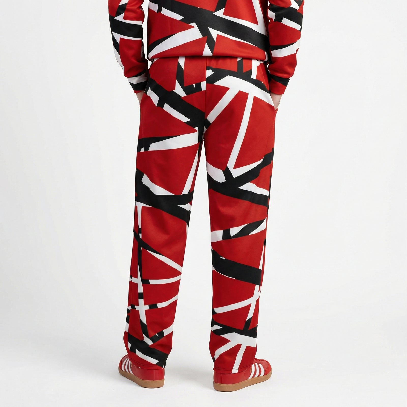 Red, black, and white patterned Frankenstripe track pants on a white background 