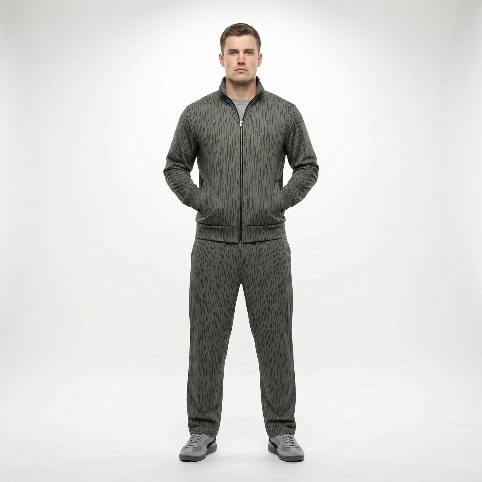 Man wearing a gray tracksuit on a white background. The tracksuit is by Liberty Maniacs and called the Strichtarn Raindrop Camo Track Jacket
