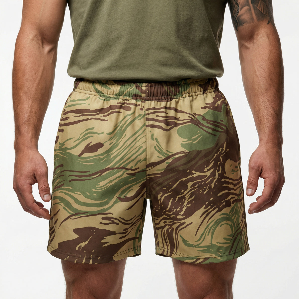Man wearing Rhodesian Brushstroke pattern camouflage shorts and a green shirt on a white background.