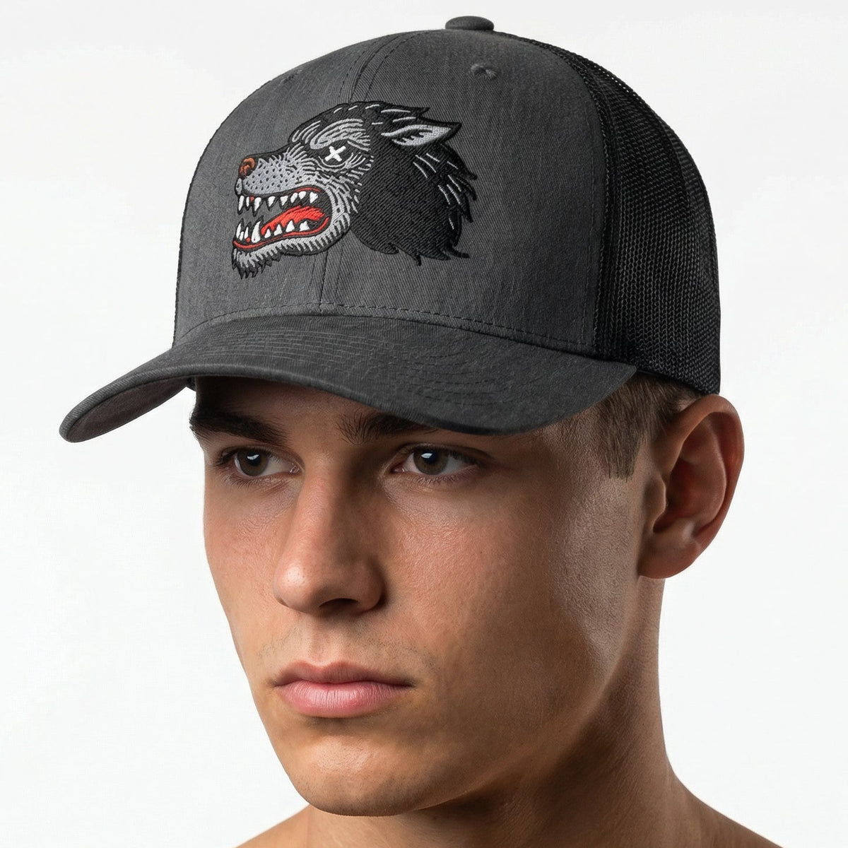 Man wearing a gray cap with a wolf design on a white background
