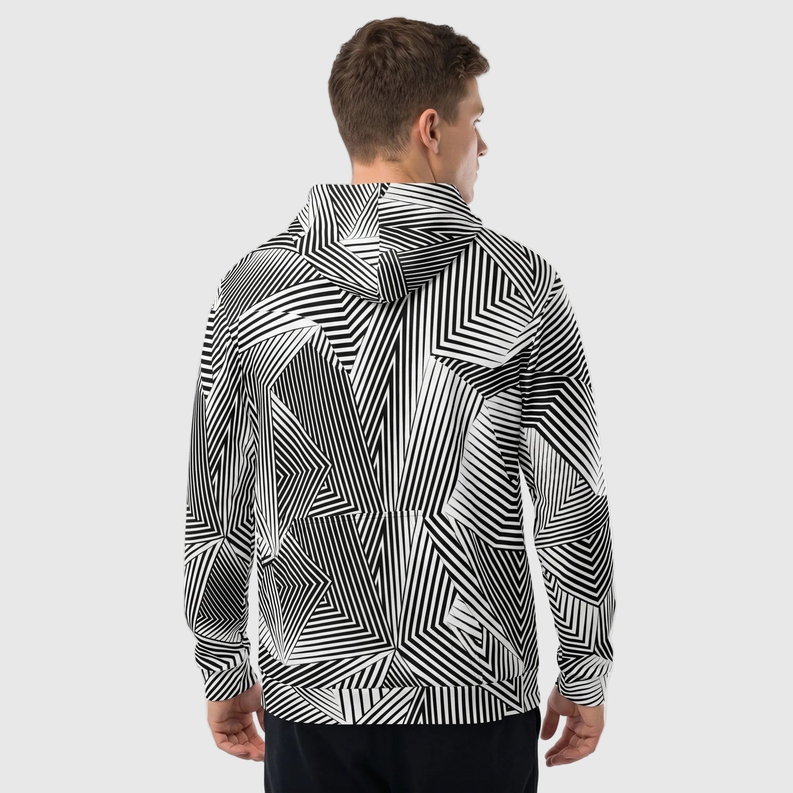 Person wearing a black and white patterned jacket on a plain background