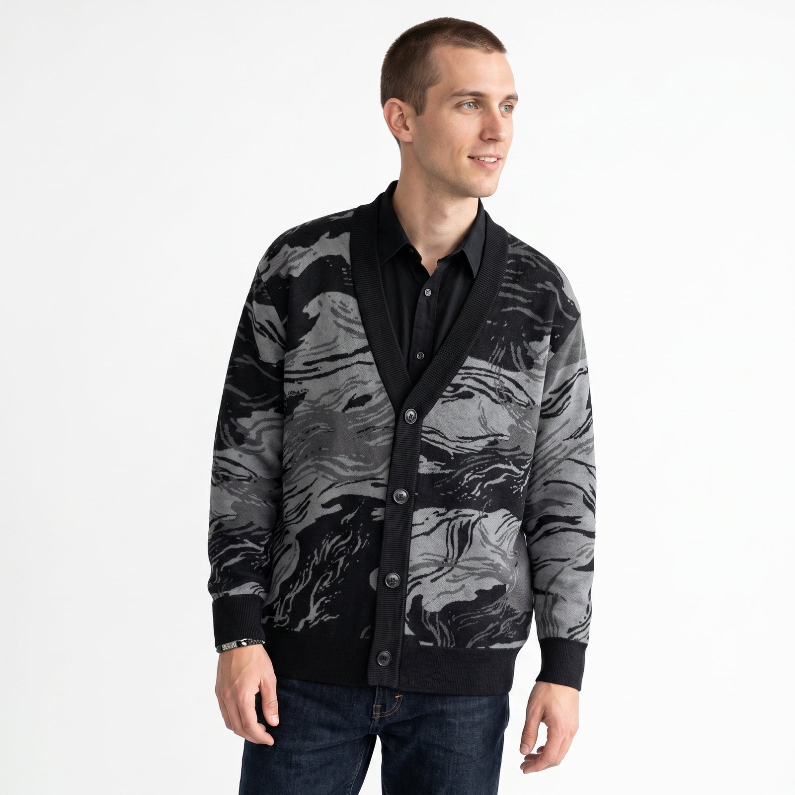 Man wearing a black and gray patterned Rhodesian Brushstroke Grey Knitted Cardigan by Liberty Maniacs
