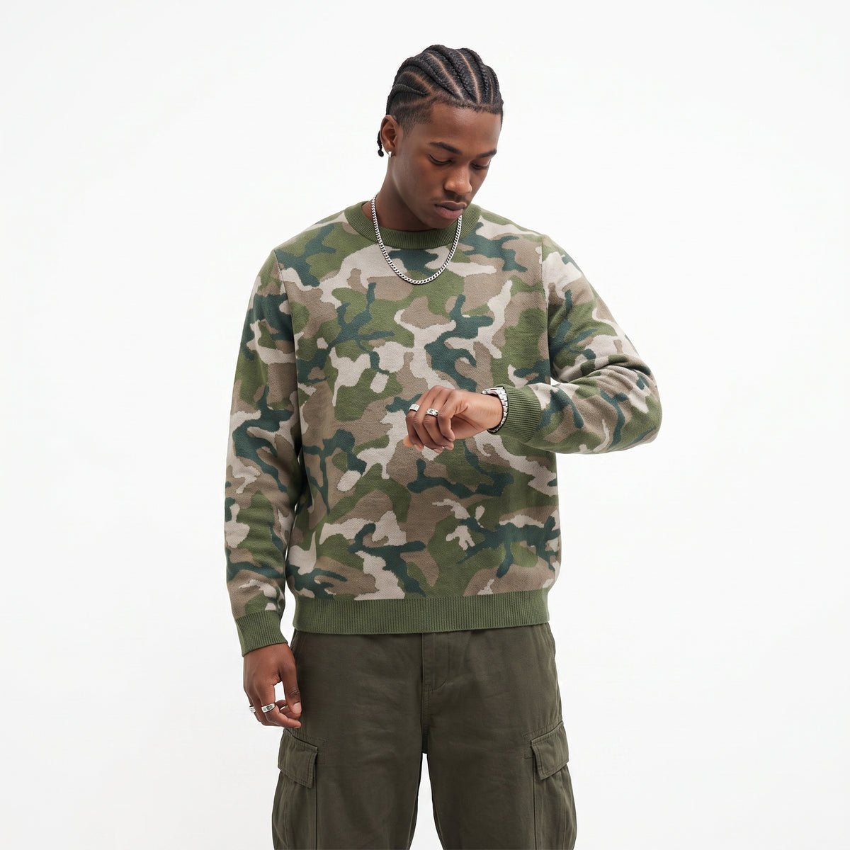 Person wearing a camouflage sweater and cargo pants on a white background