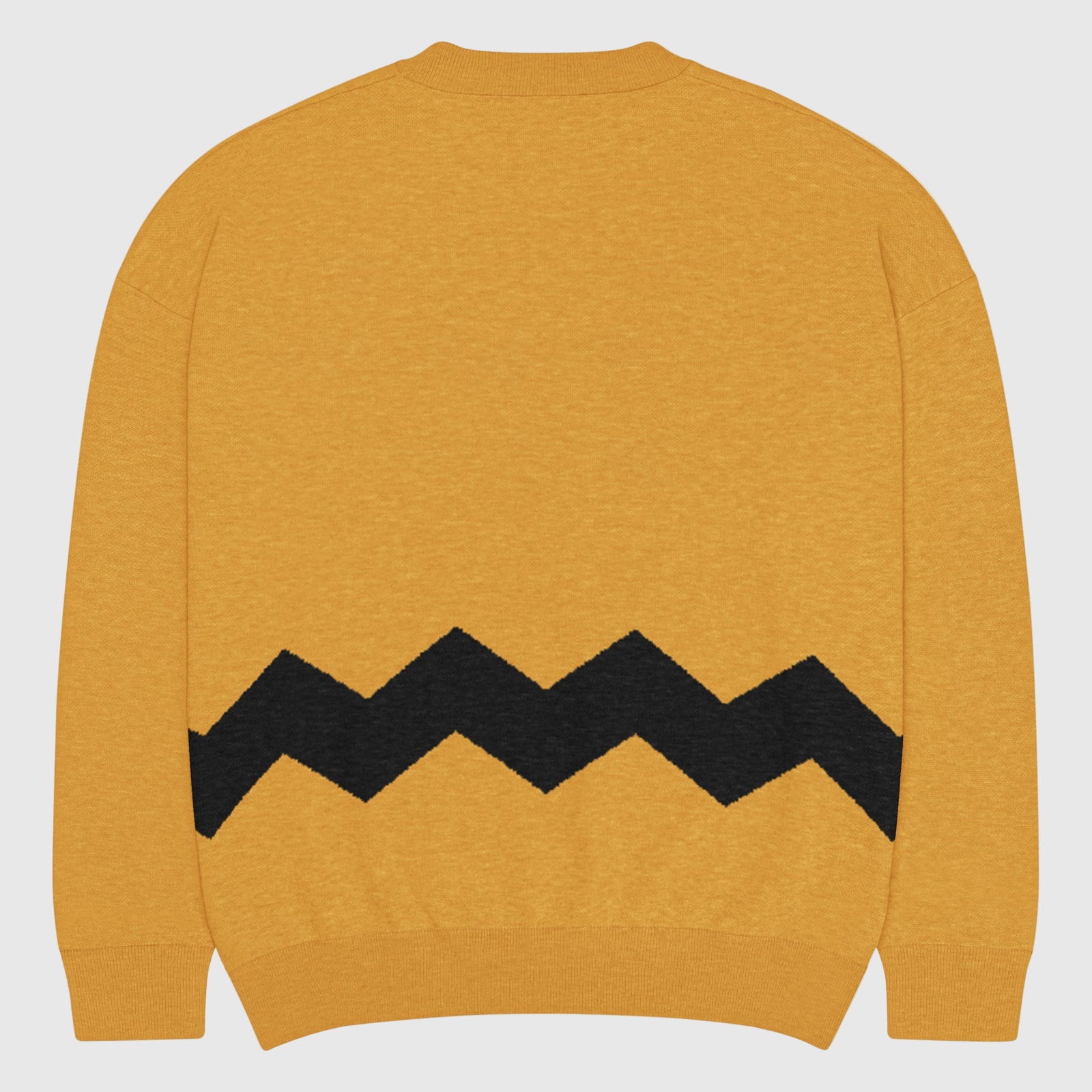 Yellow sweater with black zigzag pattern on a light gray background