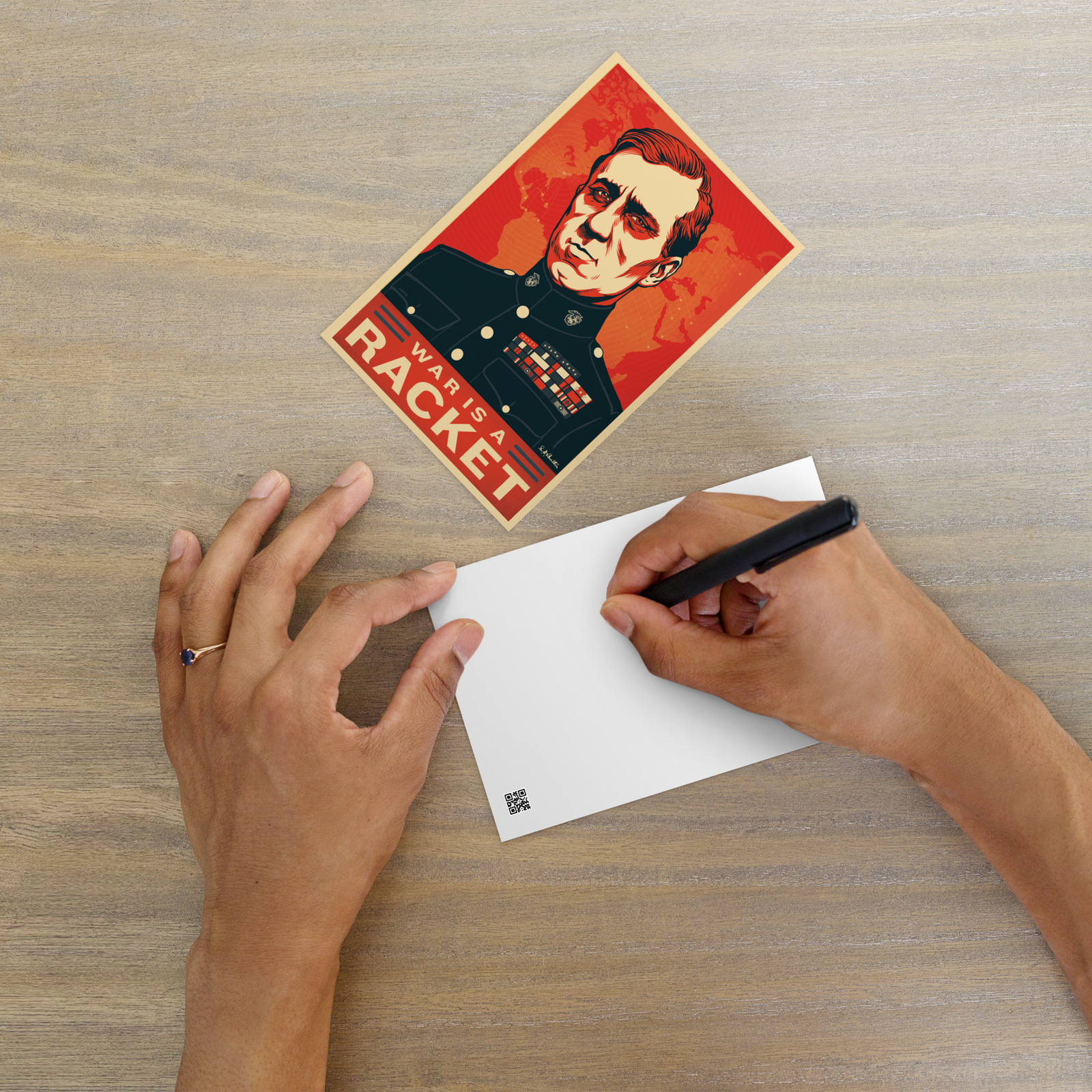 Person writing on a card with a vintage-style Smedley Butler Standard Postcard